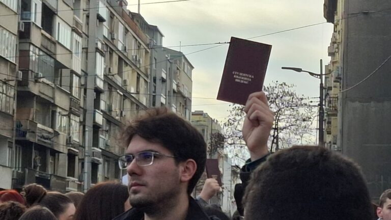 Студент држи индекс високо на протест во Србија, како симбол на отпор и борба за правда