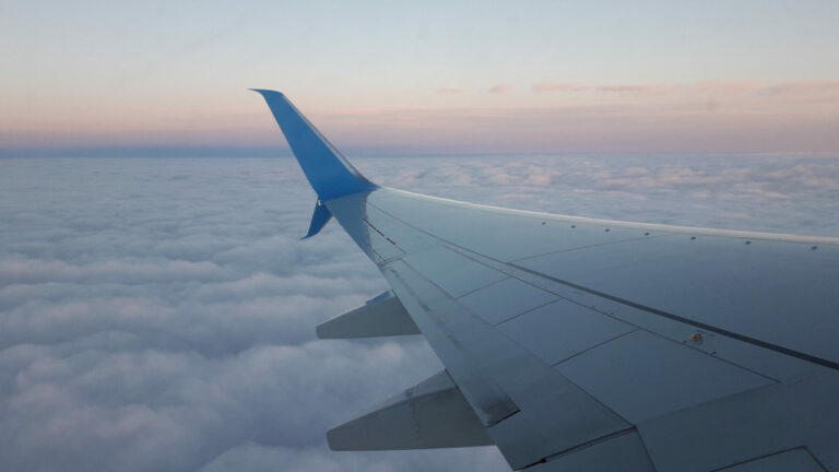 вион полетува додека сонцето заоѓа, симболизирајќи поволно и паметно патување.